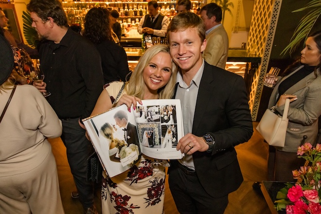 A couple holding the page of their wedding feature. 