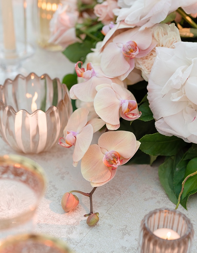 Pink orchids and white flowers detail the wedding reception.