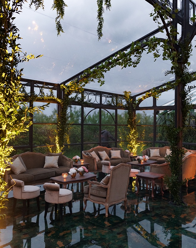 Lounge seating and greenery decorate the glass atrium. 