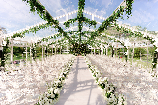 White florals and greenery detail the glass atrium for the Venetian wedding ceremony.